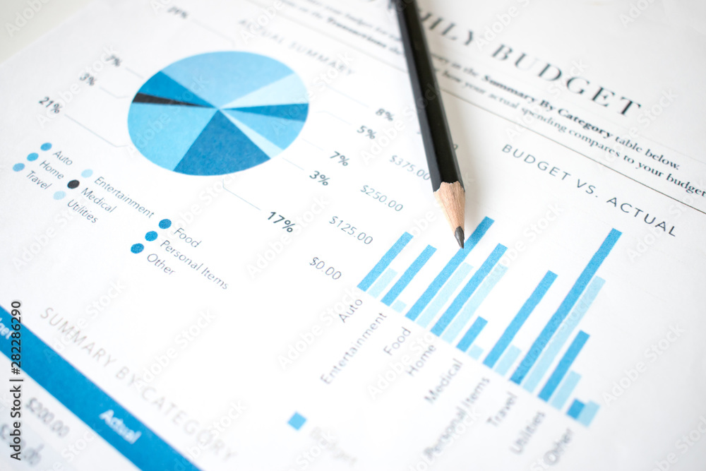The pencil is placed on the financial graph of the businessman. The pencil is placed on the financial graph of the businessman.