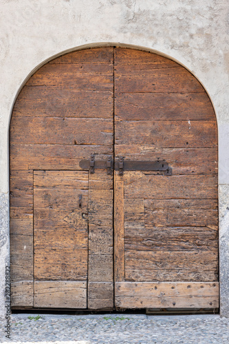 antico portone ad arco in legno con serratura, 