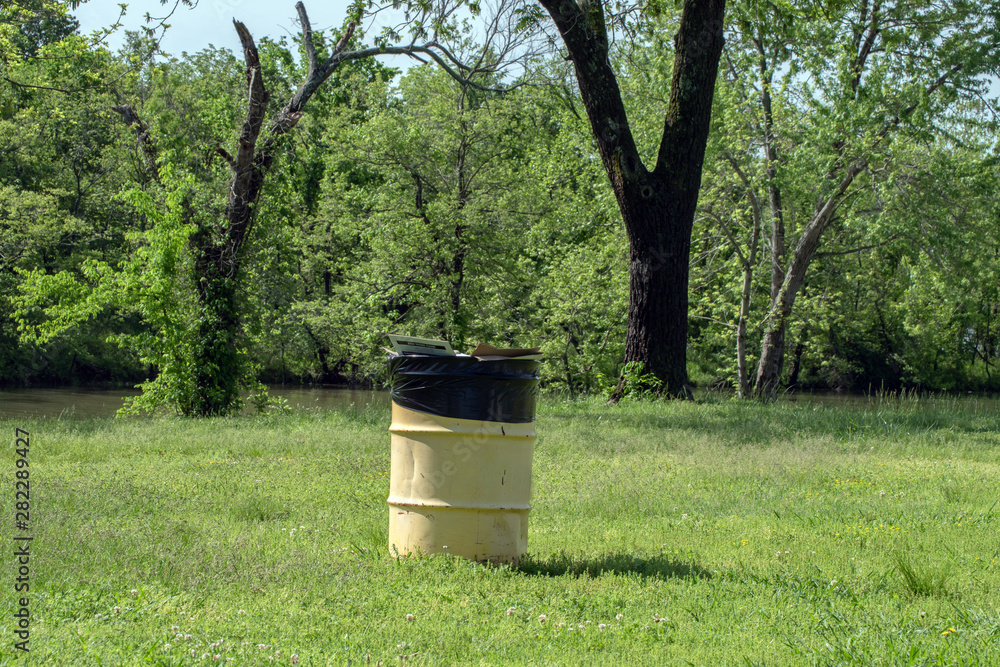 A trash barrel at the lake is an important part of keeping the area clean and tidy in Oklahoma. Bokeh. A trash barrel at the lake is an important part of keeping the area clean and tidy in Oklahoma. Bokeh.