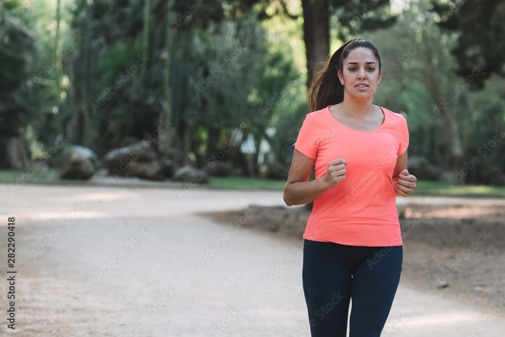 white woman smiling running through the park white woman smiling running through the park
