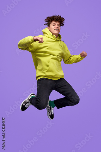 Stylish teenager jumping up in air