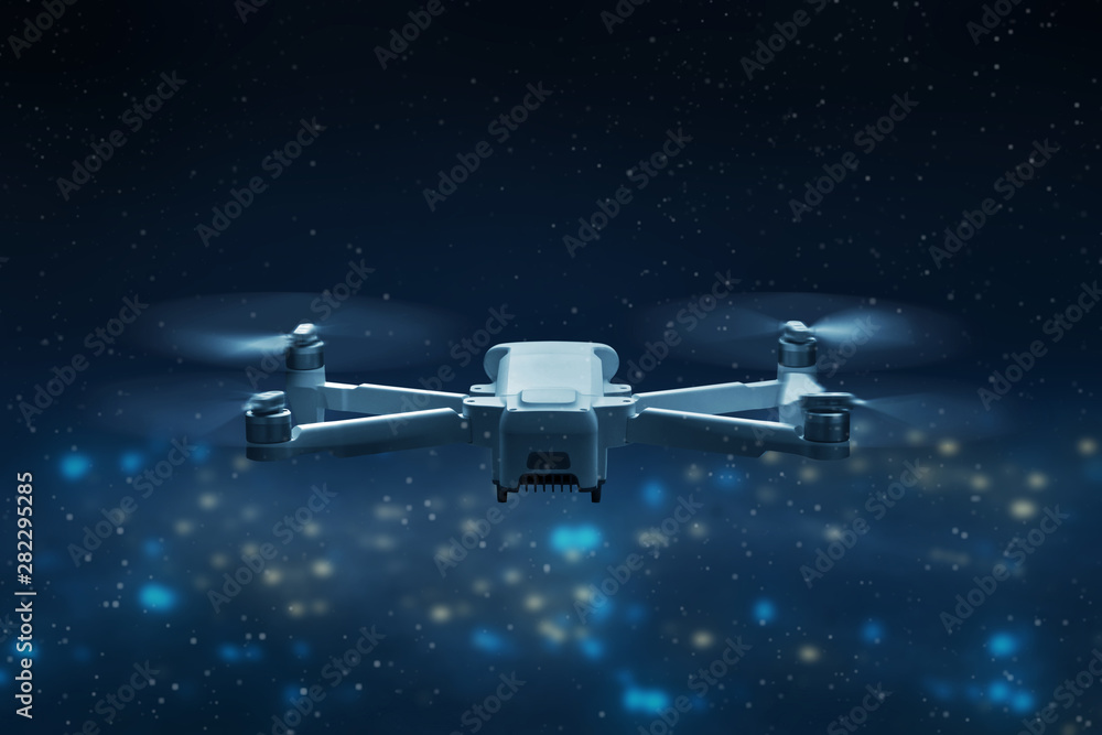Drone quadcopter flying above city at night Drone quadcopter flying above city at night