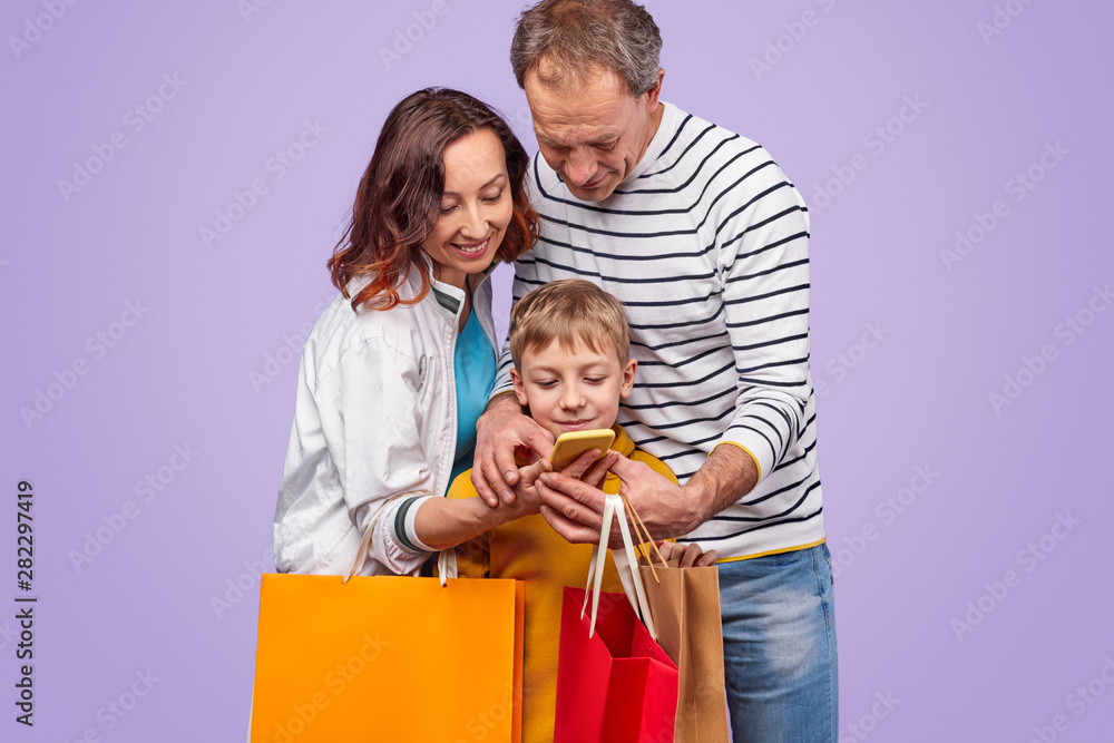 Happy family using smartphone while shopping Happy family using smartphone while shopping