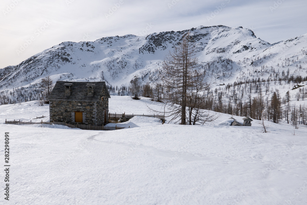 stone mountain refuge in a snowy landscape