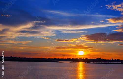 Beautiful Sunset in the sky with sky blue and orange light of the sun through the clouds in the sky  Orange and red dramatic colors over the sea. - Image