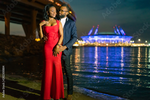 Couple in love. African fashion models. The guy is caring for the girl. African american couple. Black man and woman. Positive relationship with lovers. African American lovers in a night city