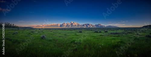 Fotografia, Obraz Panoramic view of early sun rays on the Grand Teton mountain range