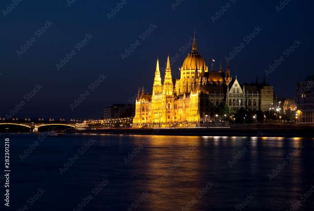 View of the Danube river and the Parliament building on the embankment at night, Budapest, Hungary