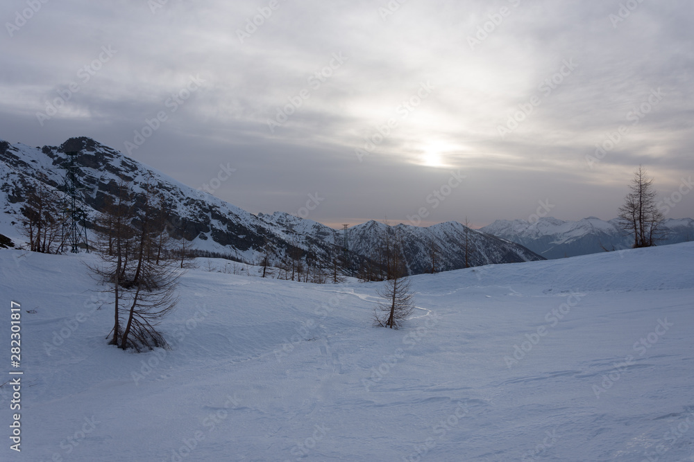 Obraz premium Snowy panorama of the Val Bognanco that opens behind Domodossola at the dawn, Piedmont