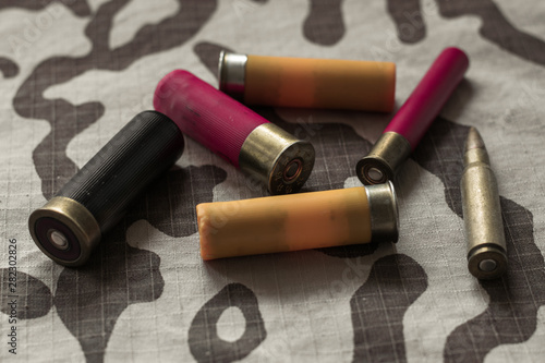 Hunting ammunition on a military uniform. Desert camouflage with a hunting cartridges on top. Bullets on camouflage fabric