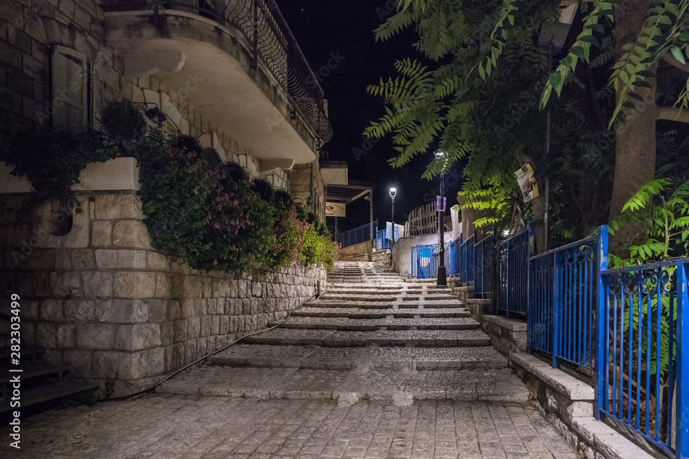 Night view of a staircase leading up from a quiet street in the old city of Safed in northern Israel