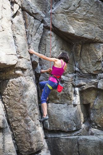 Rock climber is training on natural terrain.
