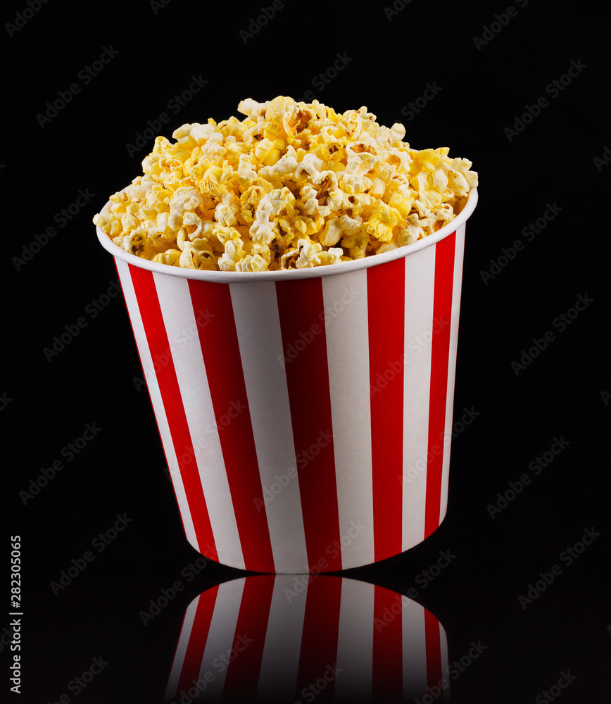 Paper striped bucket with popcorn isolated on black background Paper striped bucket with popcorn isolated on black background