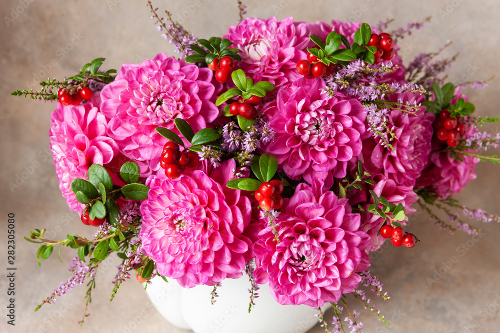 Beautiful fresh bouquet of pink dahlias in white vase.