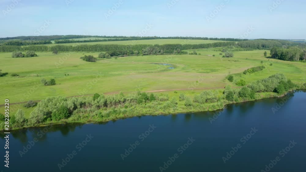 Panorama shot the area with a lake. Wonderful landscape of the lake, meadows and small areas of forest. Country roads intersecting each other are also visible. Panorama shot the area with a lake. Wonderful landscape of the lake, meadows and small areas of forest. Country roads intersecting each other are also visible.