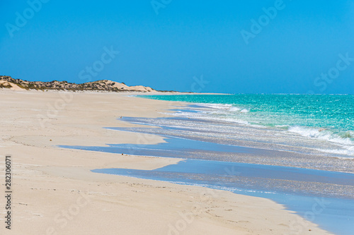 Fototapeta Naklejka Na Ścianę i Meble -  Long and empty beach of Coral Bay blue sky and turquoise water