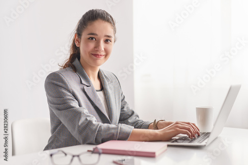 Young trainee using laptop in office photo
