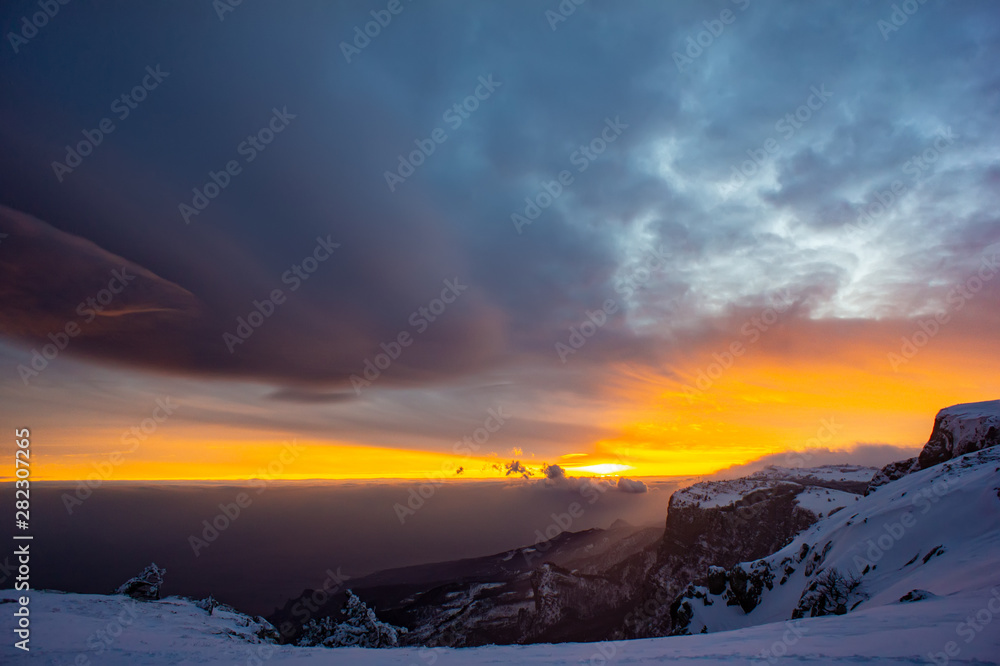 Landscape in the snow covered mountains. Sunset, february.