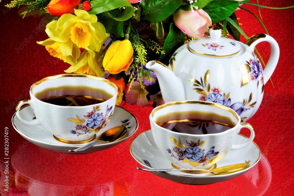 Fototapeta premium Tea party - tea in cups, teapot, garden flowers on a summer day. Daily tea is a delicious, popular, healthy, invigorating drink for Breakfast, lunch, dinner-brewing, infusion of a leaf of a tea Bush.