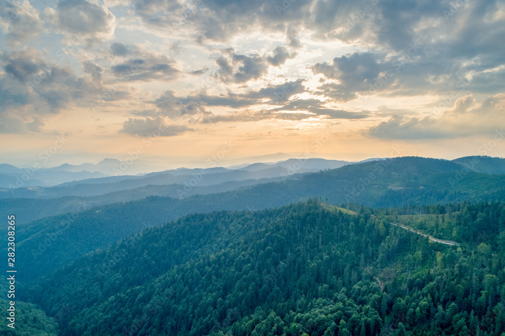 Sunset in the mountains. Forests and white clouds in the sky_1