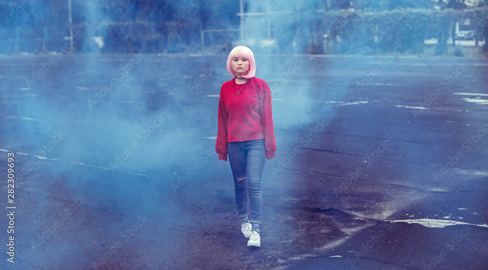 Fototapeta premium Asian teenager walking in blue smoke