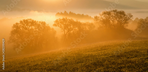Fall in Slovakia. Meadows and fields landscape. Autumn color trees at sunrise.