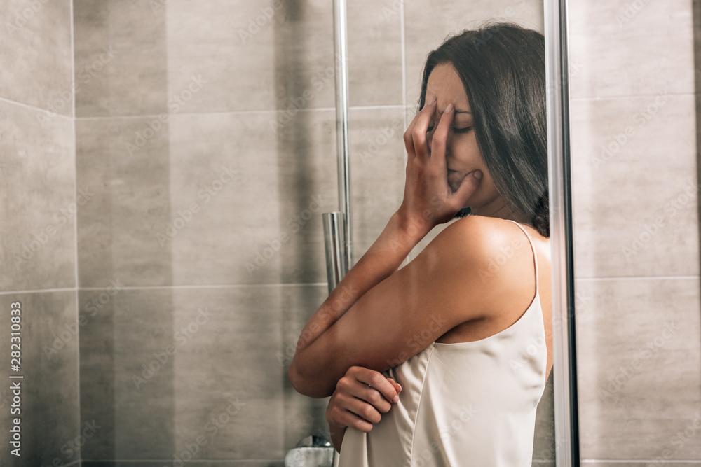 lonely depressed woman covering face and crying in shower with copy space