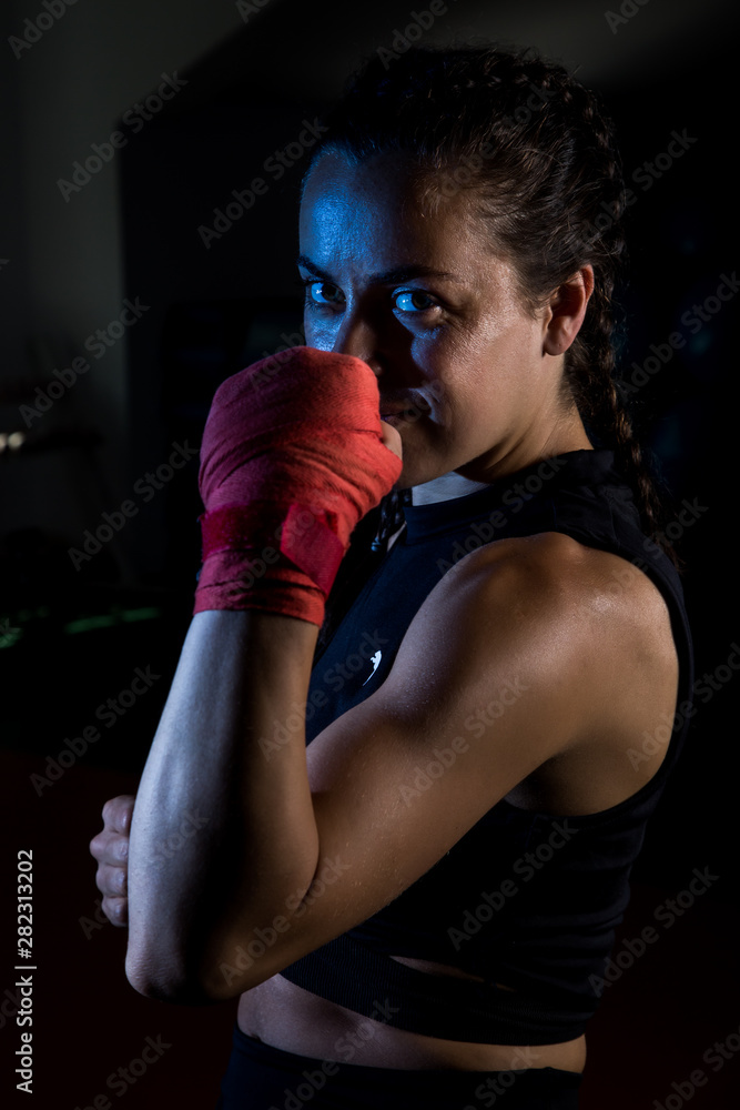 Young female boxer prepare for training in a gym. Young female boxer prepare for training in a gym.