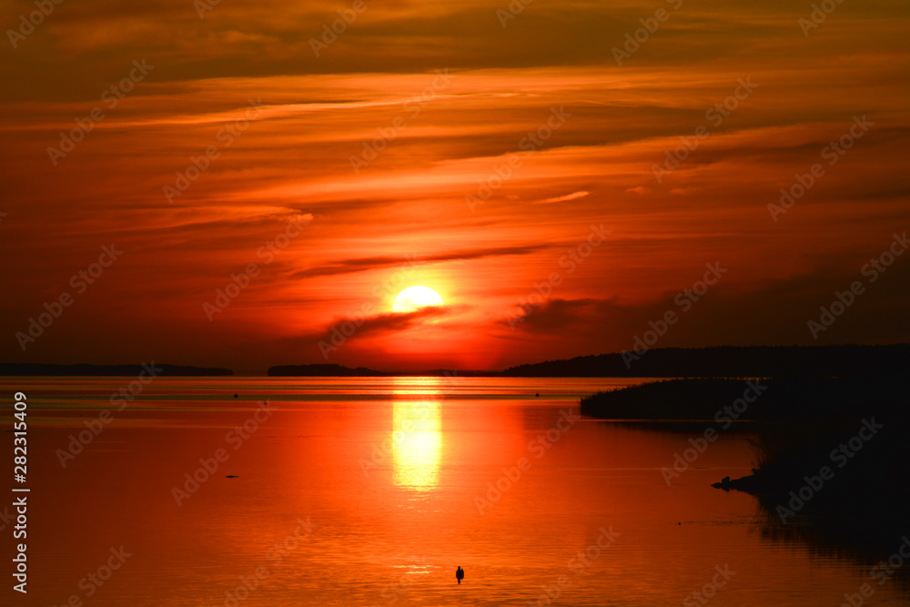 Orange sun sets in the lake