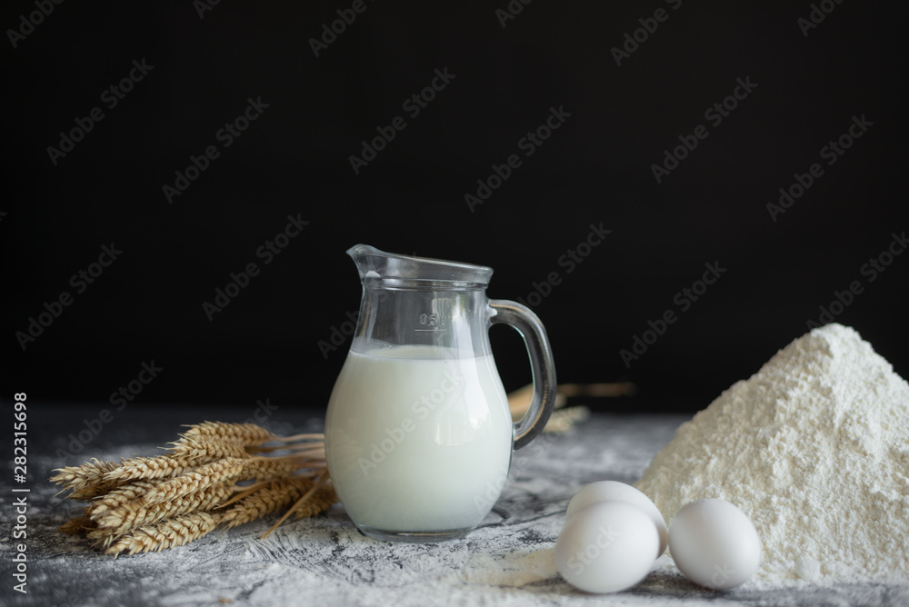 a jug of milk stands on the table, white wheat flour, ingredients for making bread a jug of milk stands on the table, white wheat flour, ingredients for making bread