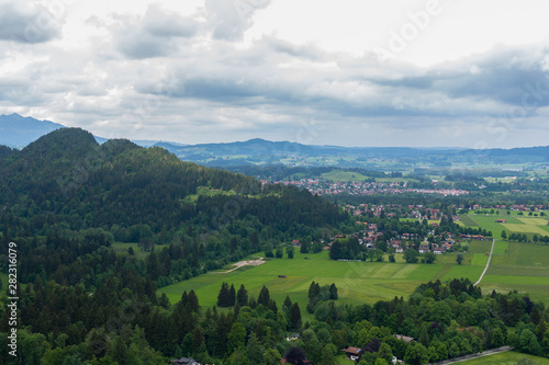 Fototapeta Naklejka Na Ścianę i Meble -  Panaramic skyline of Alps, Bavaria. Spring summer time. Postcard view. Blue sky and green fields.