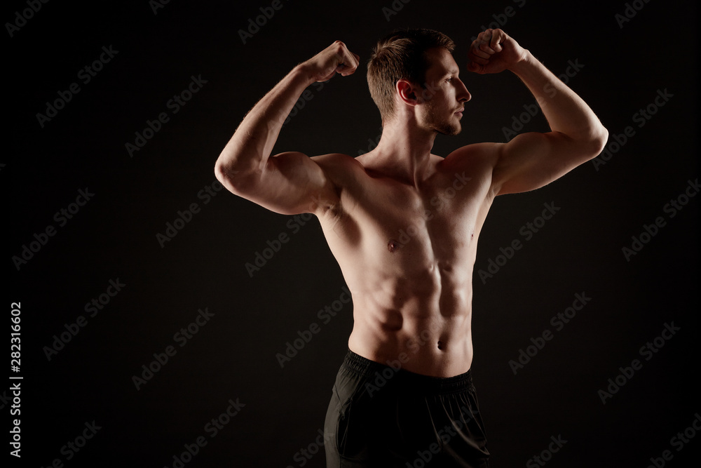 Muscular man with shirt off shows his body at the camera.