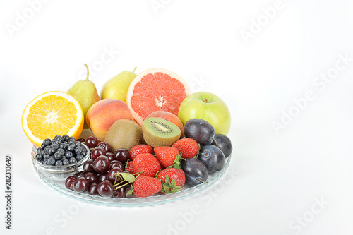 Acceptable fruits for diabetes. In a plate are orange  grapefruit  cherry  plum  pears  peaches  apple  plum  blueberries  kiwi. White background. Close-up. Free space for text.