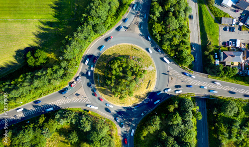 Composite aerial image of traffic using a small roundabout with multiple connecting roads photo