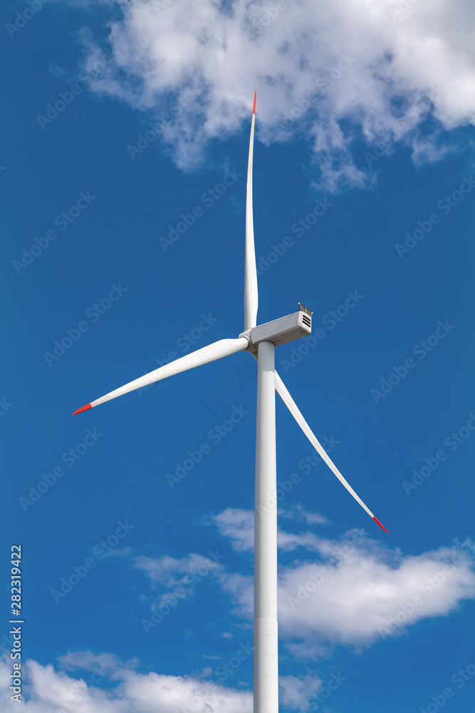 A wind turbine and blue sky with clouds. Large three-bladed horizontal-axis wind turbines produce the overwhelming majority of windpower in the world today. A wind turbine and blue sky with clouds. Large three-bladed horizontal-axis wind turbines produce the overwhelming majority of windpower in the world today.