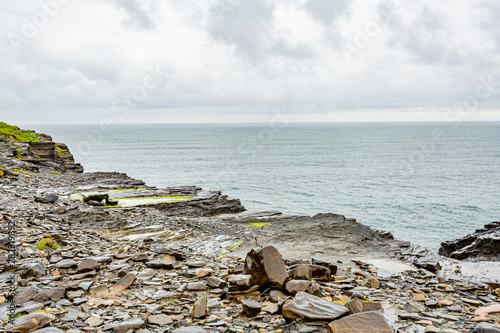 Limestone rocks and the sea along the coastal walk route from Doolin to the Cliffs of Moher, geosites and geopark, Wild Atlantic Way, spring day in county Clare in Ireland photo