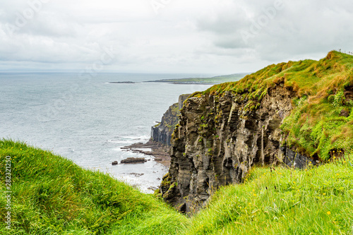 View of the rocky cliffs in the Irish countryside along the coastal walk route from Doolin to the Cliffs of Moher, geosites and geopark, Wild Atlantic Way, rainy day in county Clare in Ireland