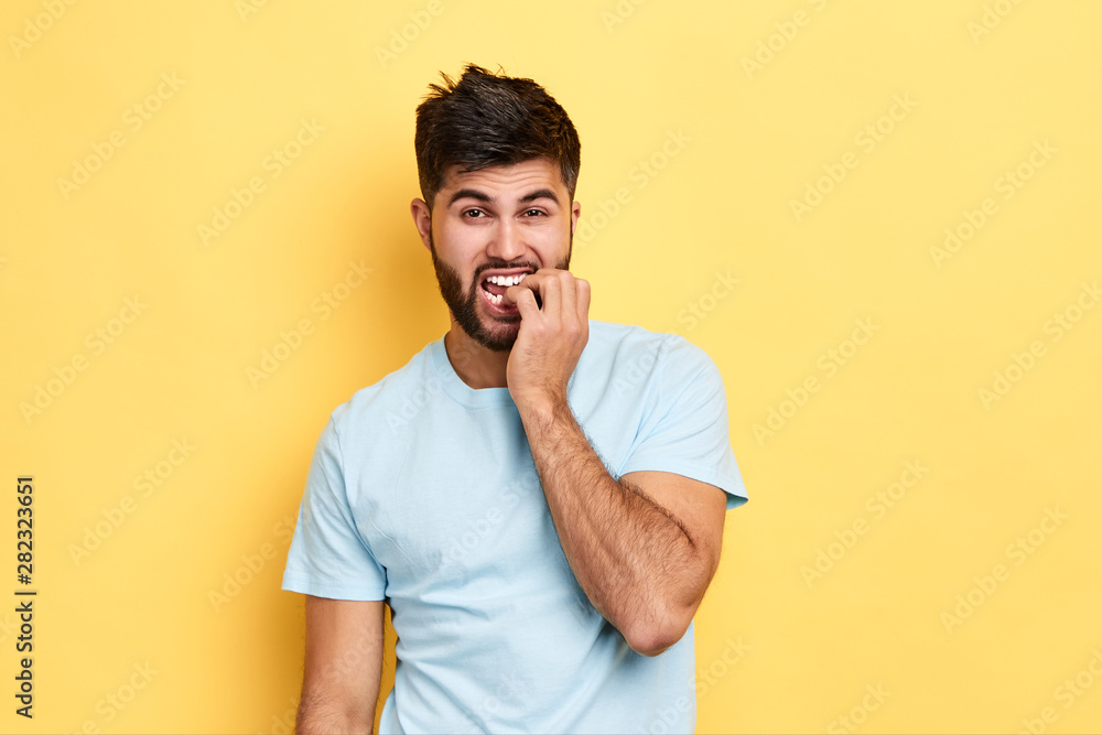 young emotional man watching football match, worried about his favourite team. close up portrait, isolated yellow background, studio shot. young emotional man watching football match, worried about his favourite team. close up portrait, isolated yellow background, studio shot.