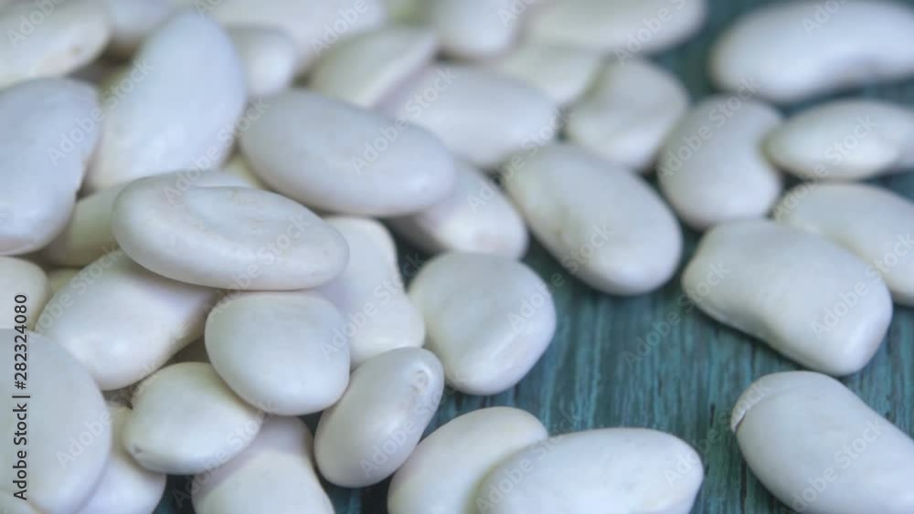 White bean lies on a wooden table. Proper nutrition. Ingredients for cooking. 360 rotation. 4K UHD White bean lies on a wooden table. Proper nutrition. Ingredients for cooking. 360 rotation. 4K UHD