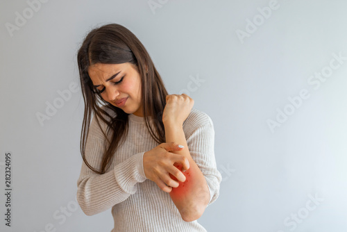 Woman Scratching an itch on white background . Sensitive Skin, Food allergy symptoms, Irritation. People scratch the itch with hand, Arm, itching, Concept with Healthcare And Medicine. photo