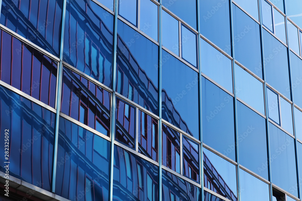 Obraz premium Modern business building windows. Blue Glass Facade with Geometric Lines, Reflection