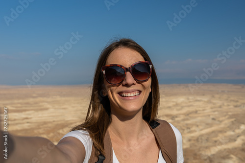young woman taking a selfie in the desert of israel