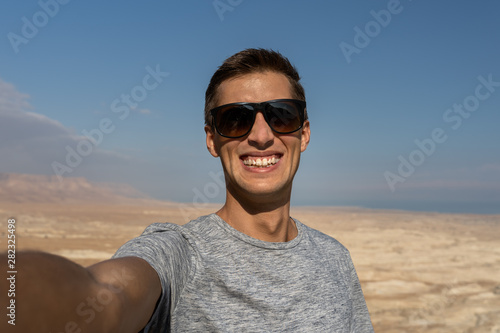 young man taking a selfie in the desert of israel