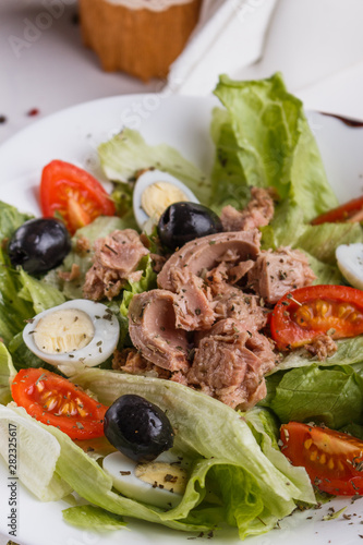 Fresh salad with iceberg lettuce,tomatoes,eggs,canned tuna and olives