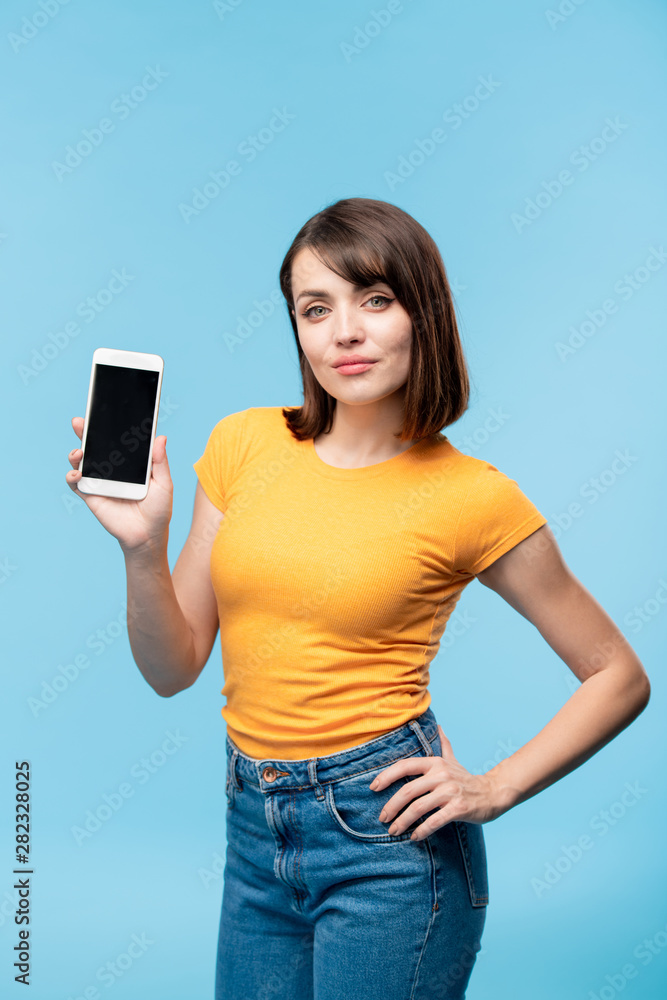 Fototapeta premium Young woman showing you advert or notification on screen of smartphone