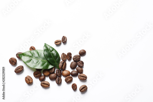 Vászonkép Fresh green coffee leaves and beans on white background, top view