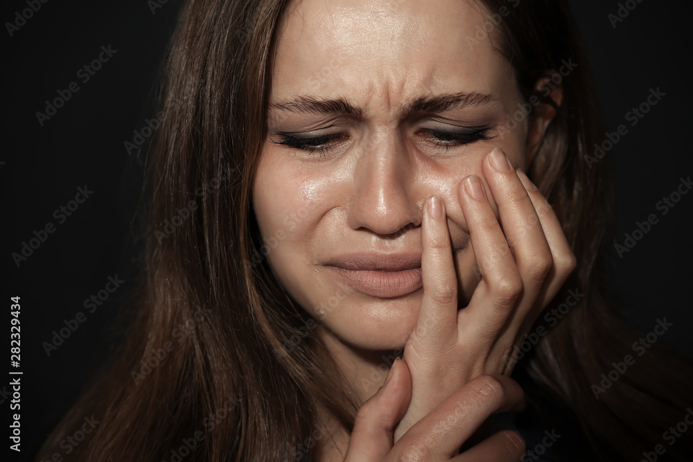 Crying young woman on dark background. Stop violence Crying young woman on dark background. Stop violence