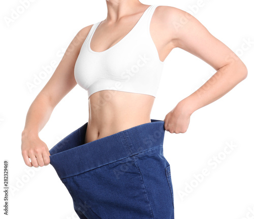 Young slim woman wearing oversized jeans on white background, closeup