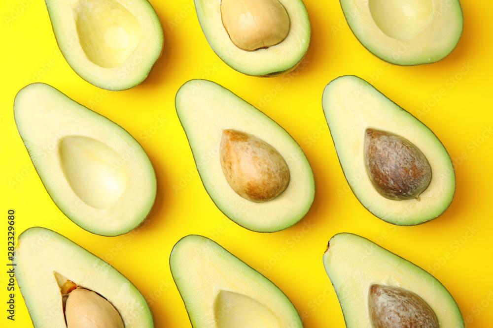 Cut fresh ripe avocados on yellow background, flat lay Cut fresh ripe avocados on yellow background, flat lay
