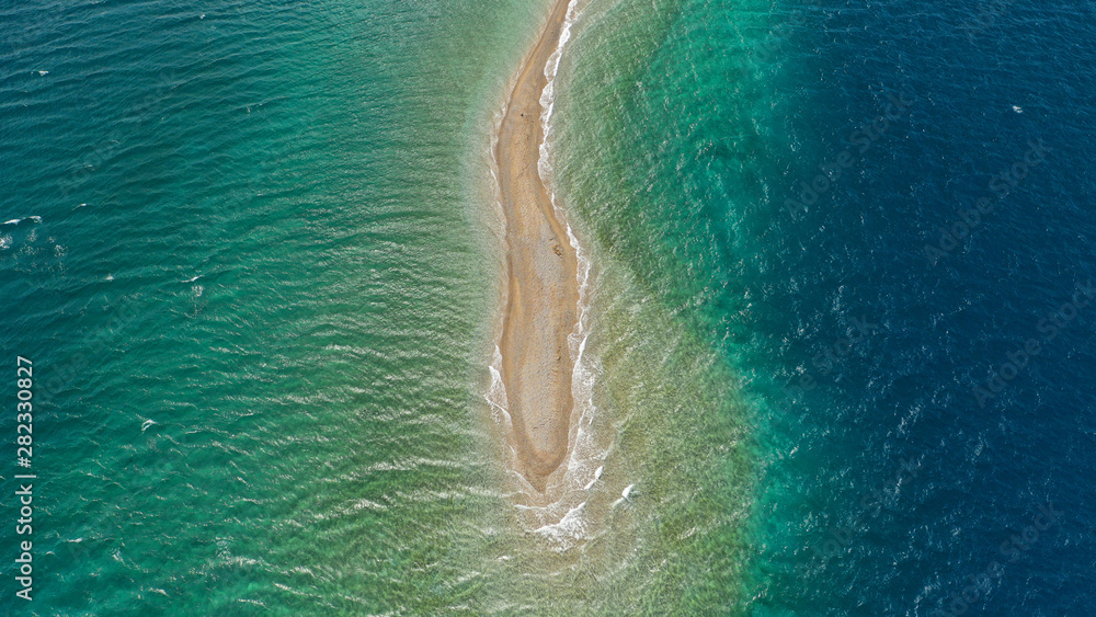 Aerial drone photo of tropical exotic island sand bar separating sea in two with turquoise and sapphire breathtaking colours